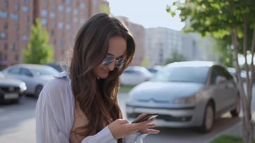 Stylish Woman Using Phone on City Street