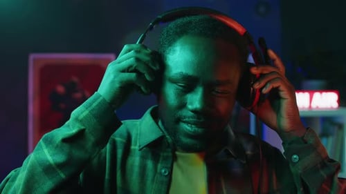 Smiling Man Puts On Headphones With Microphone