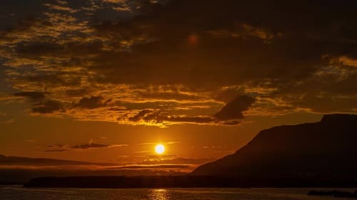 Lever de soleil Théâtral sur les montagnes islandaises Nuages oranges épiques dans le ciel se déplaçant en timelapse