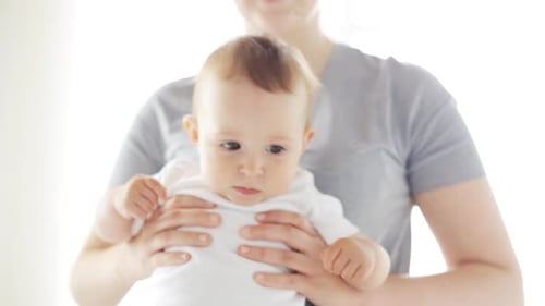 Smiling infant being held by an adult