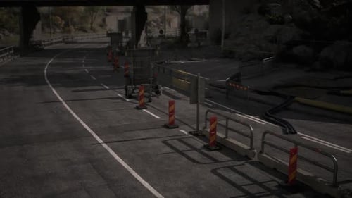 Construction Activity Along a Winding Road at Dusk with Traffic Barriers