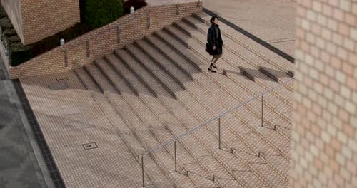 Japanese woman walking up steps in business district Tokyo, Japan