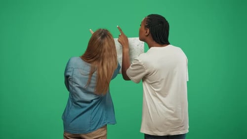 Young Adults Planning Adventure on Map in Studio