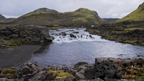 Volcanic river carving through mossy rocks
