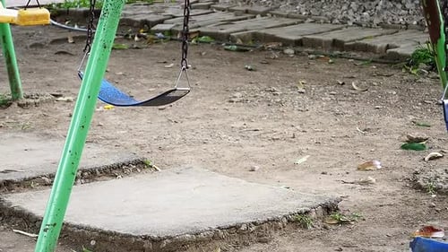 A set of kiddie swings in an old playground facility at a suburban residential subdivision in Mandau