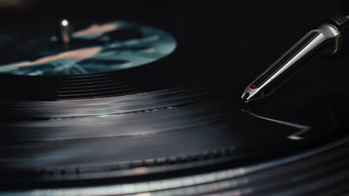 Close-up of a vinyl record as the turntable's stylus needle drops to start playing a song.