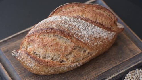 A loaf of homemade whole grain rye bread for the dinner table. A loaf of rye bread