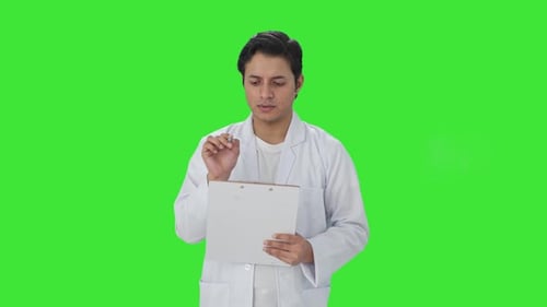 Indian scientist writing observations on papers Green screen