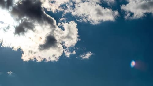 Timelapse of Cumulus Clouds Moving In The Blue Sky Against The Sun
