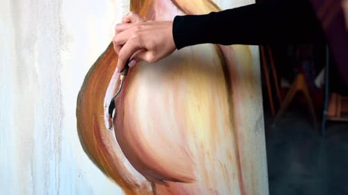 Beautiful woman painting with watercolors at an art gallery workshop