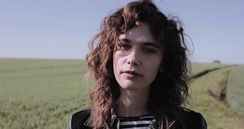 Portrait of Young adult woman in field looking to camera