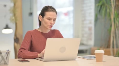 Woman Massaging Stiff Neck at Work