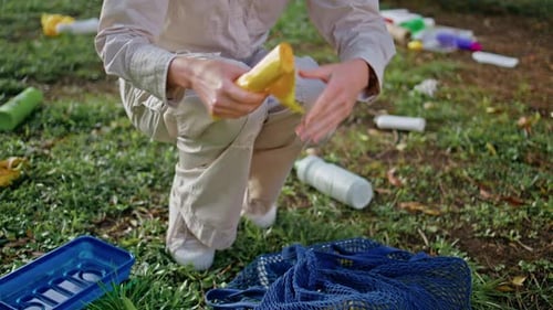 Una mujer lleva una bolsa de plástico a mano en una acción de limpieza en Green Park Closeup Eco Volunteer