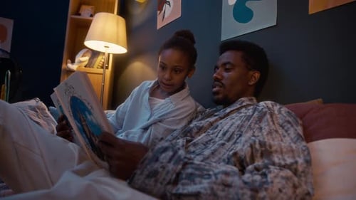 Father Reading Bedtime Story to Daughter at Home