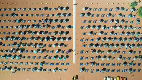 Aerial View of Crowded Beach with Blue Umbrellas