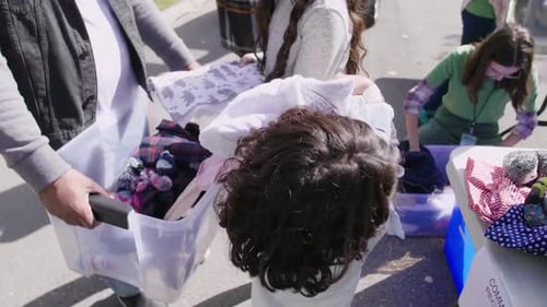 Family Volunteers Unloading Clothing for Community Event