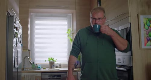 Man Drinking Coffee in a Modern Kitchen