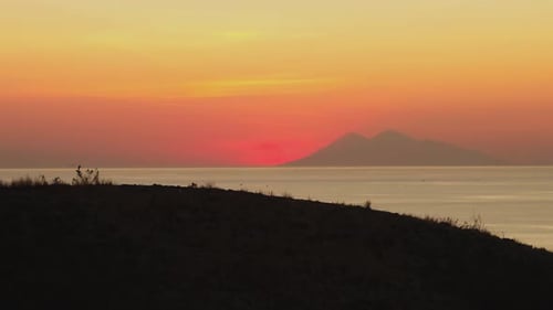 Coucher de soleil tropical ardent et silhouette de l'île | Vue aérienne de Labuan Bajo