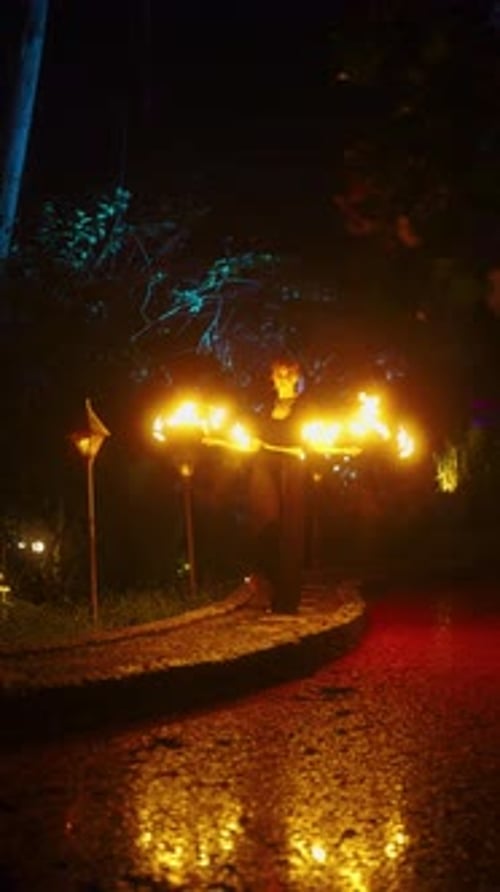 Performer Juggling Fire Torches in the Night