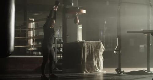 Powerful Young Sportswoman Practicing Kettlebell Swing Exercise in Club