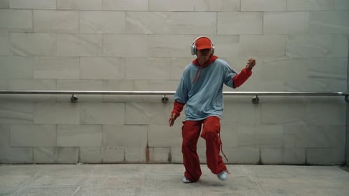 Handsome choreographer practice street dance in gray background. Sprightly.