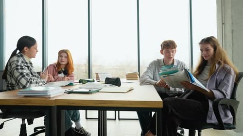 High School or College Students Studying and Reading Together in Library Education Concepts
