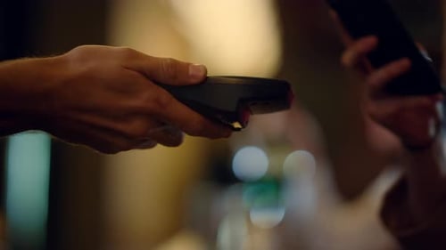 Macro Unknown Hand Giving Terminal to Visitor for Mobile Phone Payment Indoor