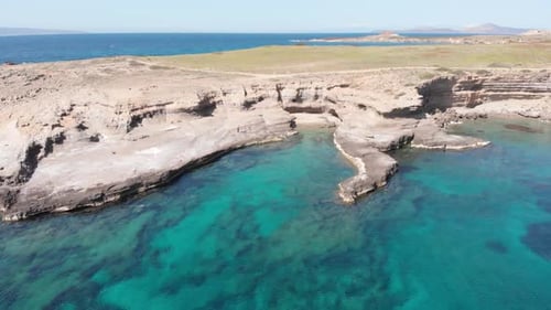 Aerial beautiful beach and water bay in the greek spectacular coast line. Turquoise blue transparent