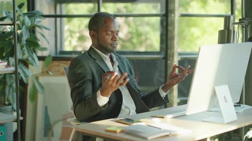 Close Up Calm African American Businessman Take a Break to Sit at Work Desk Do Yoga Meditation at