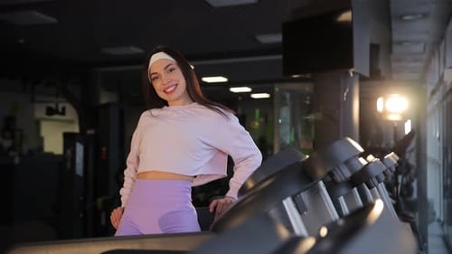 A Woman is Walking on a Treadmill in a Gym