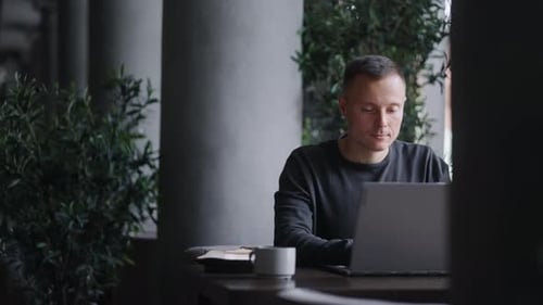 Travailleur indépendant avec un ordinateur portable à l'heure du déjeuner dans un café Portrait d'un homme avec un ordinateur portable