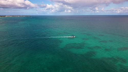 A Solitary Speedboat Leaving a White Wake on the Vast Emerald Ocean Representing Travel and Freedom