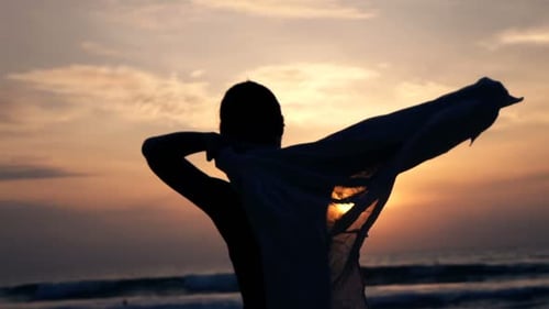 Sunset Beach Woman Putting on Shirt