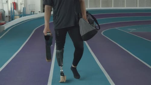 Runner with Prosthetic Limb and Blade Arriving at Indoor Stadium