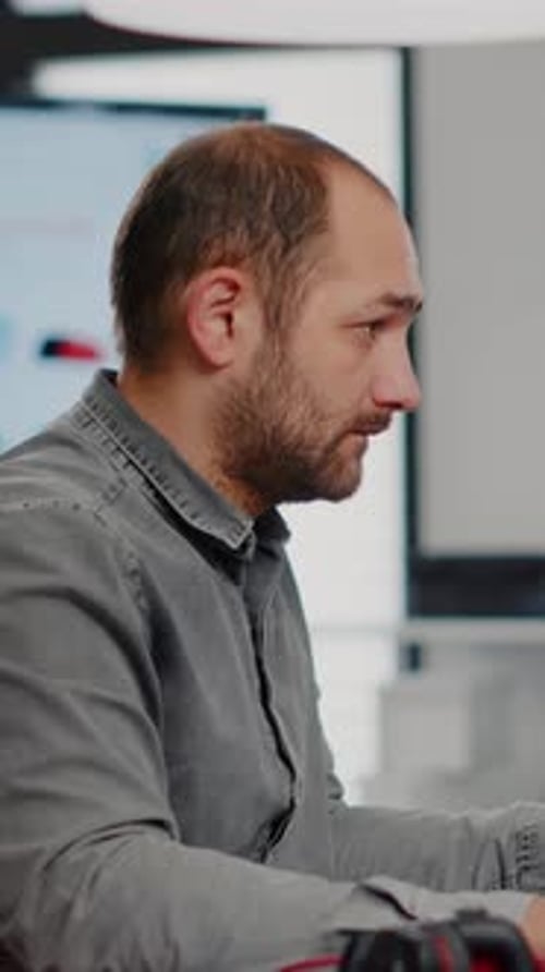 Man Works at Computer in Modern Office Setting