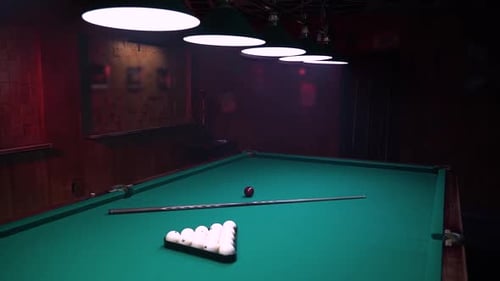 Billardkonzept, Bälle und Queue auf dem Tisch im Poolclub in einem stimmungsvollen Raum mit Rauch