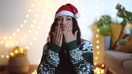 pretty caucasian woman making video call at christmas time with christmas hat waving looking at came