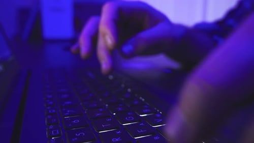 Mains masculines avec un ordinateur portable au-dessus de la tête en train de taper au ralenti la nuit