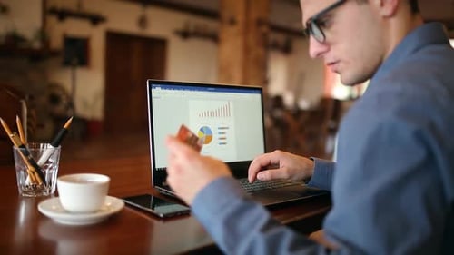 Young Man Shopping on the Internet and Paying with Credit Card Handsome Freelancer Businessman in