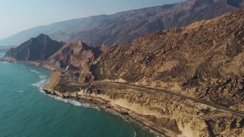 driving vehicle on the coastal road alongside the rock mountain beach in sunset time the wind erosio