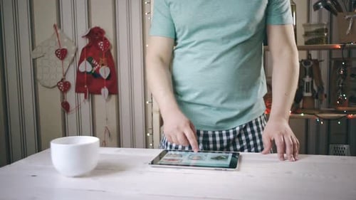 Man using tablet for online recipe in kitchen