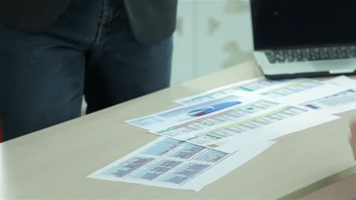 Business Handshake Over Charts in an Office