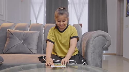 Happy Indian girl kid completes a jigsaw puzzle