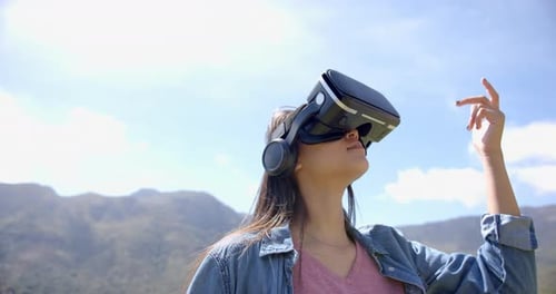 Woman Uses VR Headset Outdoors in Mountain Landscape