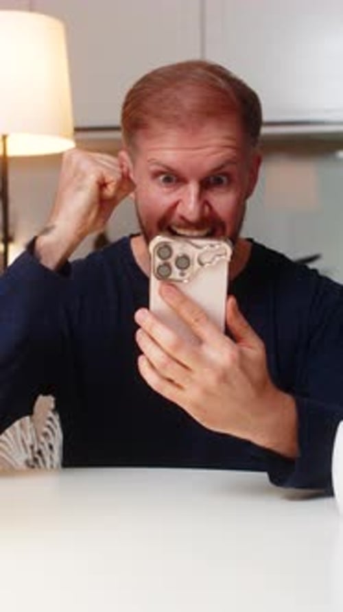 Man Using Phone Reacts to Good News
