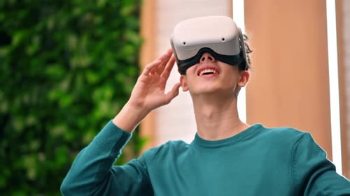 A young excited caucasian man exploring virtual reality using VR glasses in an office