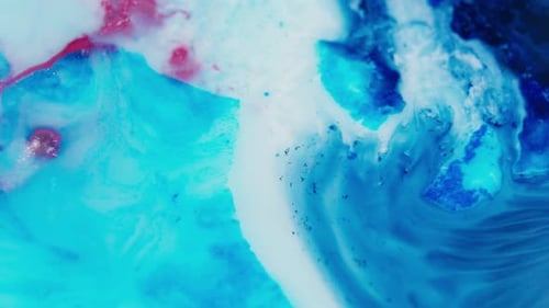 Encre bleue et rouge vibrante qui tourbillonne dans l'eau pour créer un motif abstrait fascinant