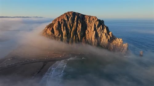 Breathtaking Aerial View of Majestic Coastal Rock Formation Overlooking a Foggy Ocean