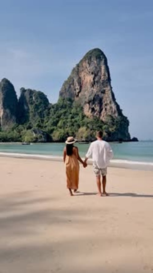 Couple Strolls Hand in Hand Along the Stunning Shores of Railay Beach Krabi Thailand