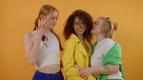 Three Friends Embracing in Colorful Studio